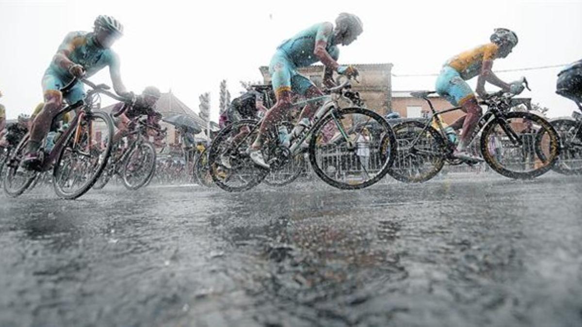 Nibali, con el jersey amarillo de líder, rueda bajo la lluvia escoltado por dos compañeros del Astana camino de Bergerac, ayer.
