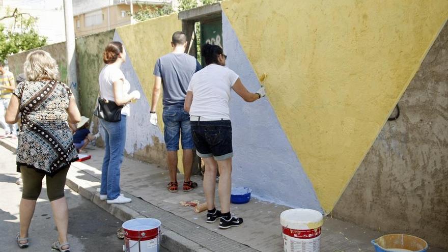 Varios vecinos de Puente Tocinos dan color a una fachada.