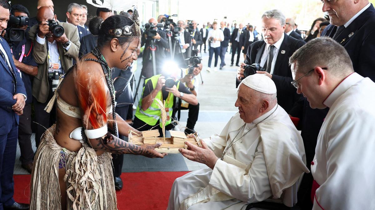 El papa Francisco recibe un obsequio de una mujer indígena el día de reunión con las autoridades, la sociedad civil y el cuerpo diplomático en APEC Haus, en Port Moresby, Papúa Nueva Guinea