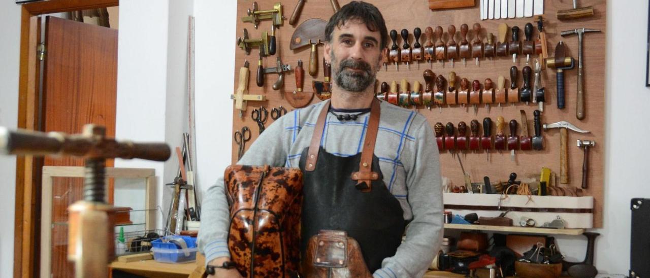 Isaac Romero en su taller en Moaña con la mochila inspirada en el caparazón de una tortuga que se ha hecho famosa.