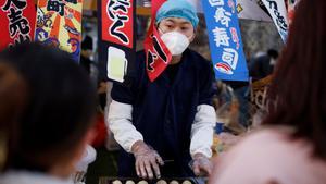 Un hombre vende comida callejera en un distrito comercial mientras China regresa al trabajo a pesar de los continuos brotes de la enfermedad por coronavirus (COVID-19) en Beijing, China