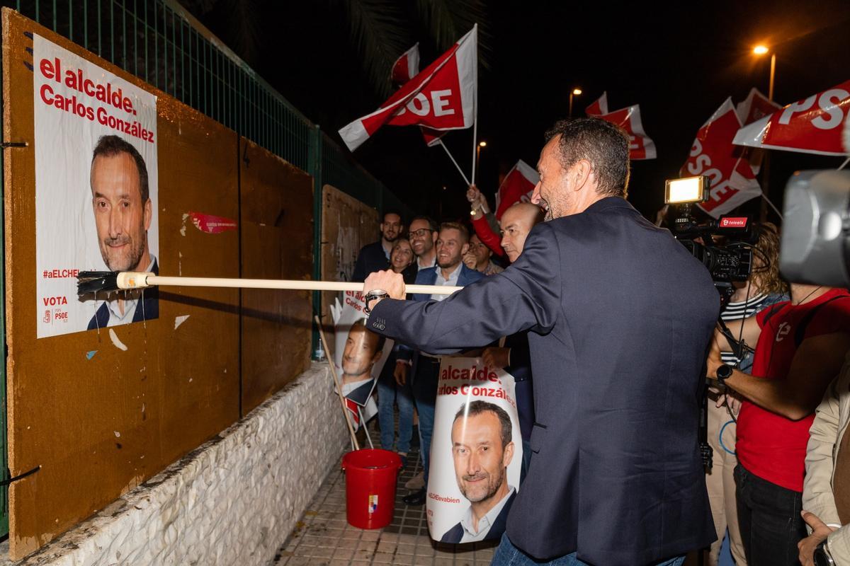 Carlos González pega su cartel electoral