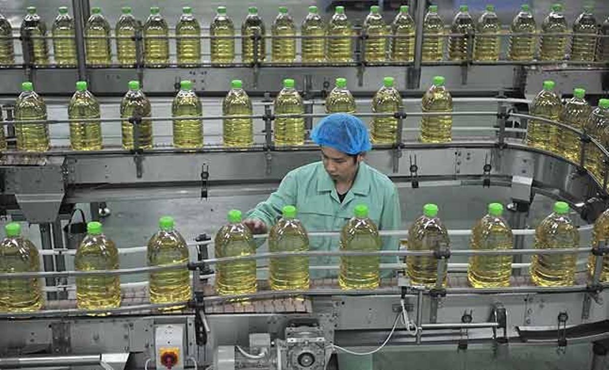 Un treballador a la cadena de producció de la fàbrica d’oli de soja Huifu, a Sanhe, a la província de Hebei (Xina)