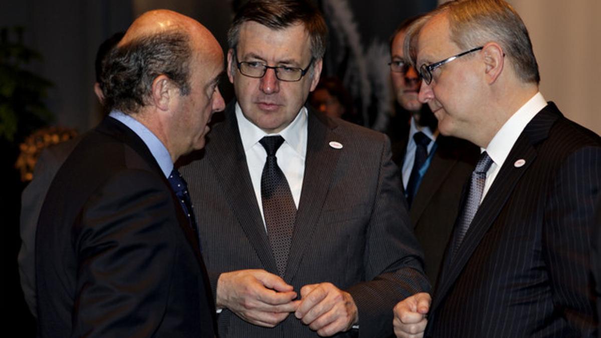 El comisario económica de la UE, Olli Rehn (derecha) y el ministro de Economía belga, Steven Vanackere (centro) escuchan las explicaciones de Luis de Guindos.