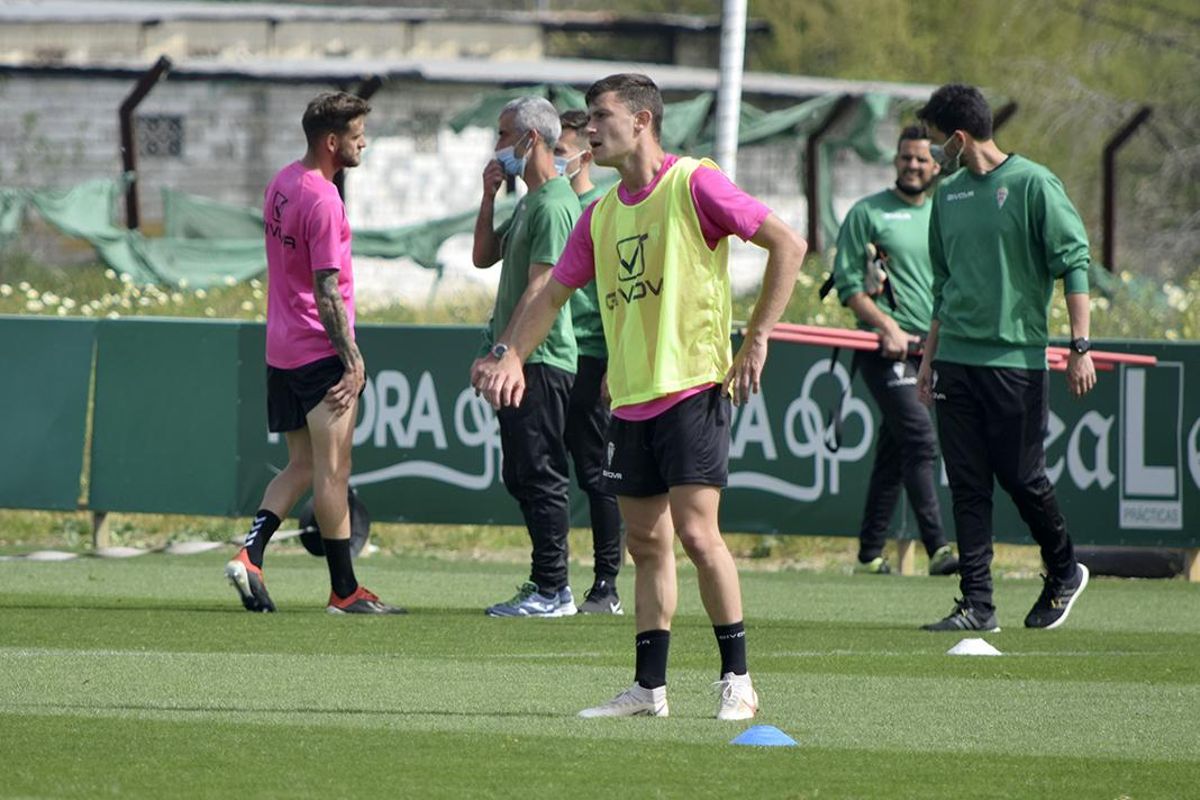 Nahuel, al fondo, se dirige al doctor Bretones señalándose la zona dolorida en el entrenamiento de hoy.