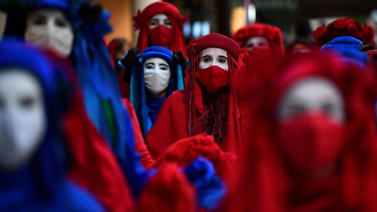 Los miembros de la Brigada Rebelde Roja, una compañía activista de performance internacional, llegan a la estación central de Glasgow.