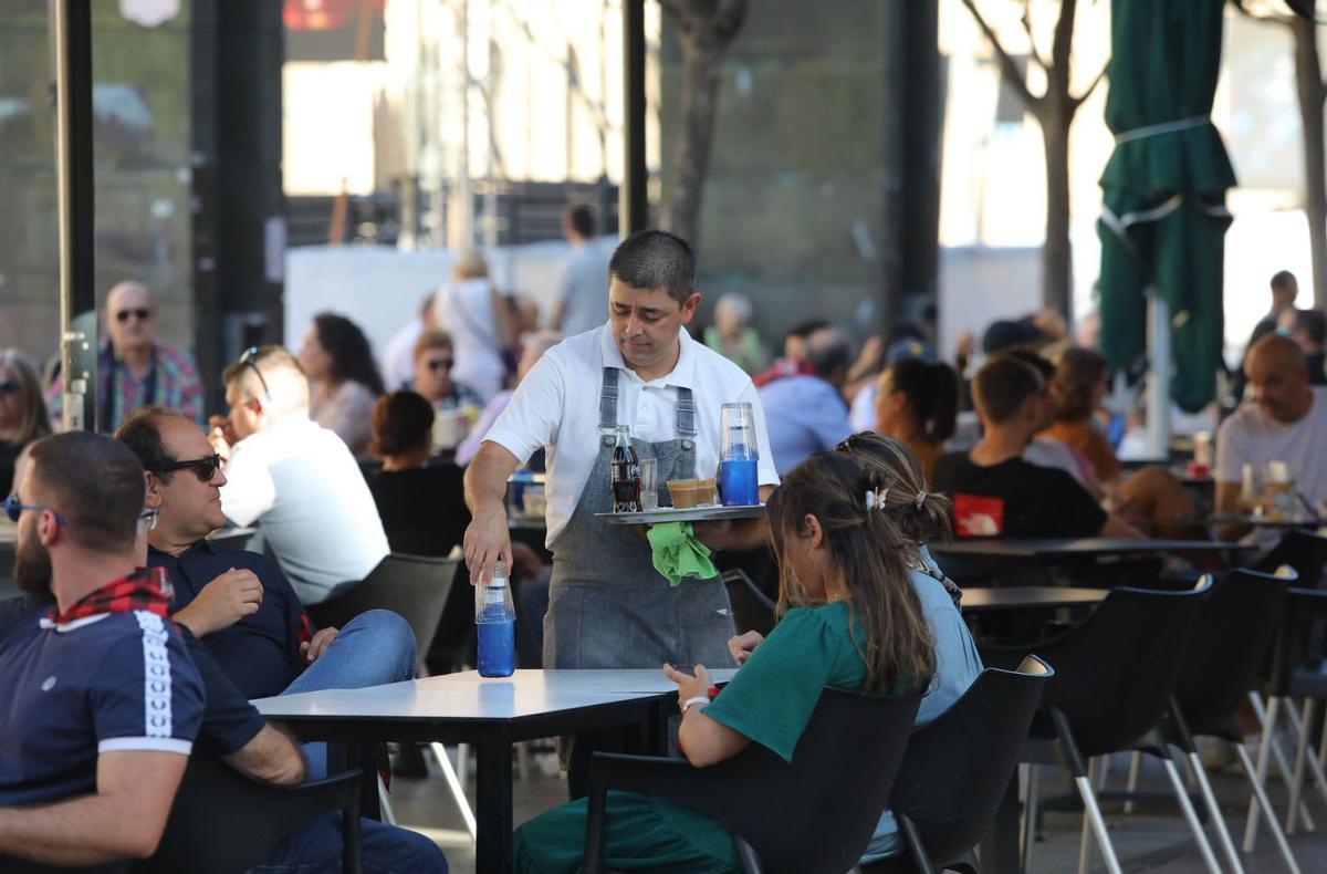 Un camarero atiende una mesa en un bar de la plaza del Pilar de Zaragoza.