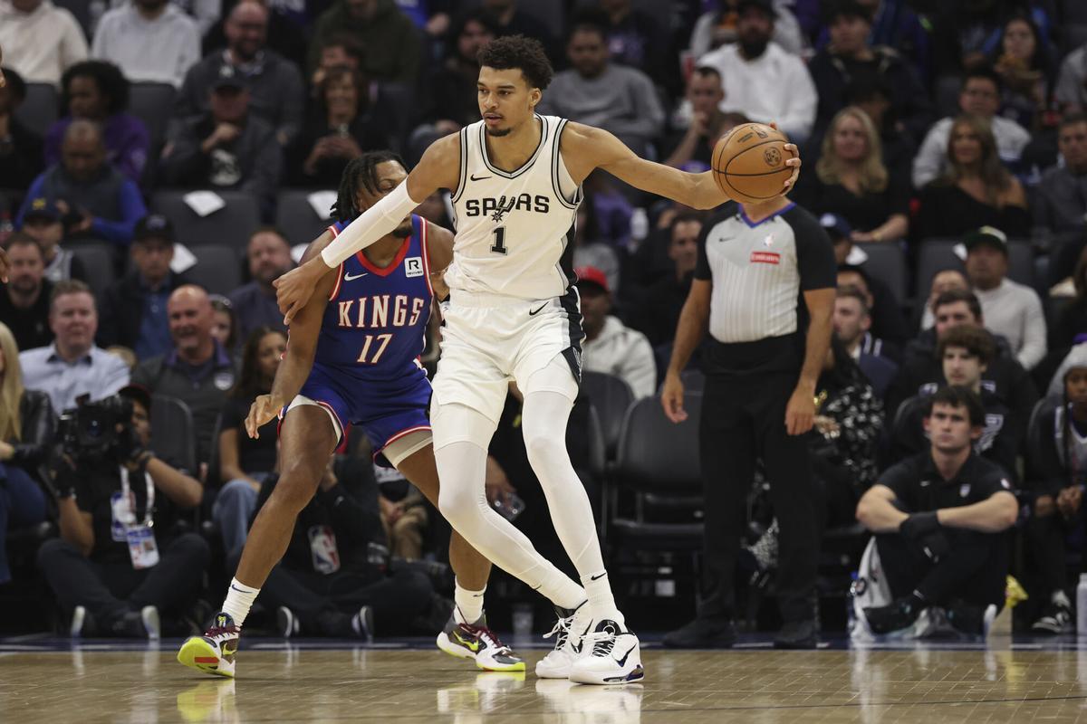 San Antonio Spurs center Victor Wembanyama (1) is defended by Sacramento Kings center Isaac Jones (17) against the Sacramento Kings during an NBA basketball game in Sacramento, Calif., Sunday, Dec. 1, 2024. (AP Photo/Jed Jacobsohn)