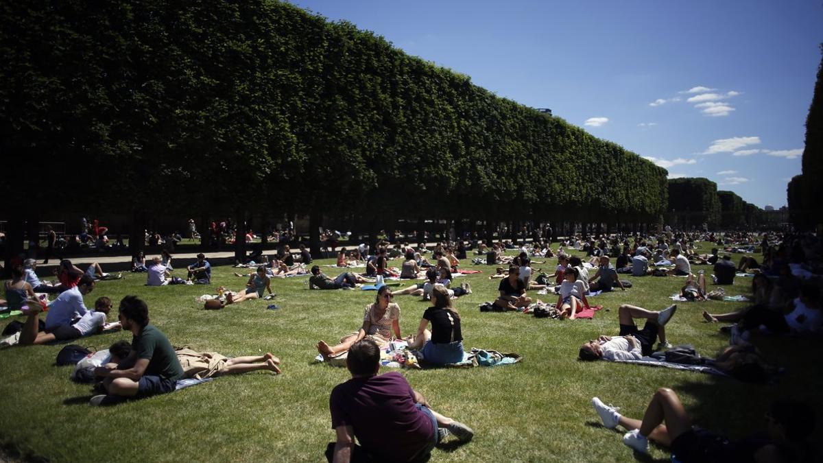 Decenas de parisinos toman el sol en los Jardines de Luxemburgo de París.