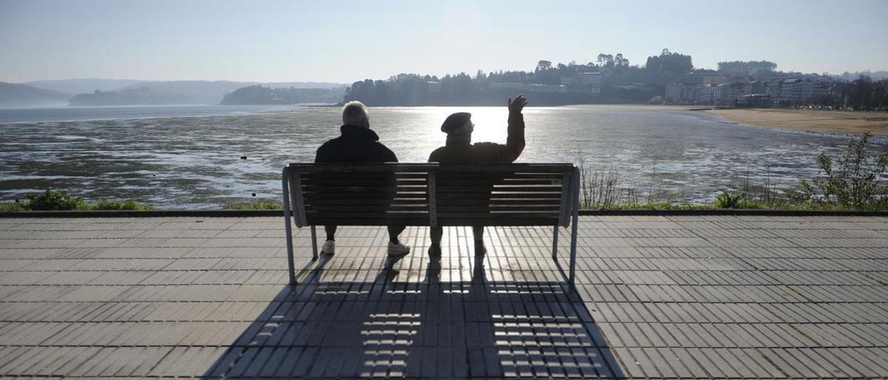 Dos bombres mayores toman el sol una mañana soleada.