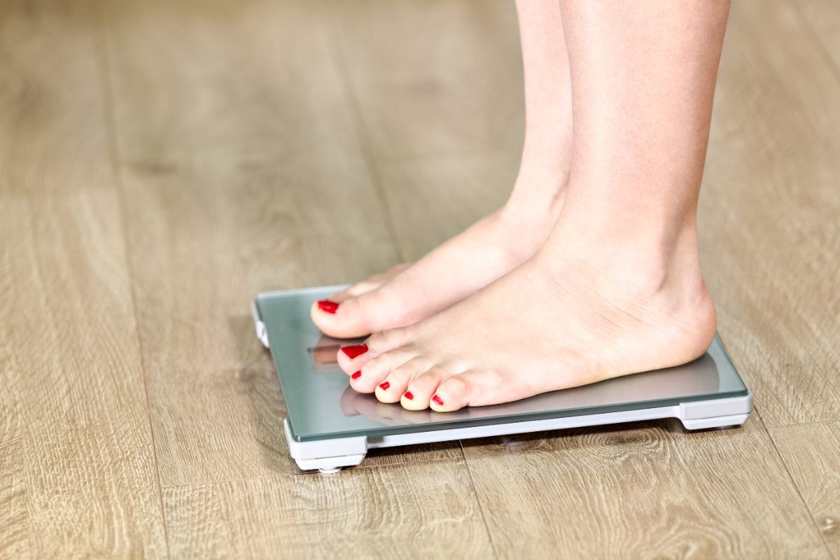 Mujer sombría haciendo ejercicio con pesas en el gimnasio de casa