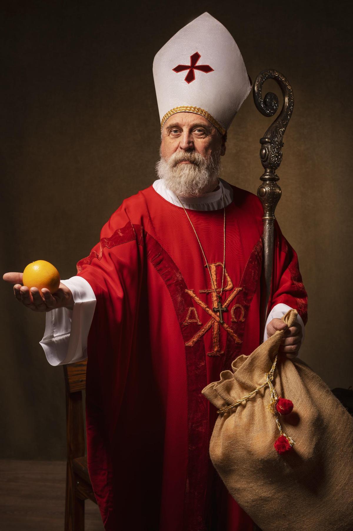 Sinterklaas sostiene una naranja, uno de los símbolos tradicionales asociados a su llegada desde el sur de Europa.