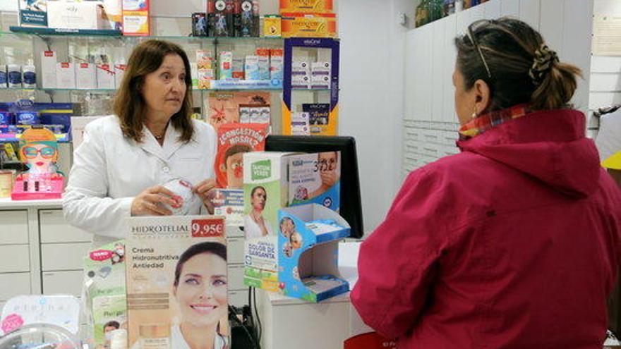 La responsable de la farmàcia Noguera de Girona ensenyant les mascaretes que els queden als compradors.