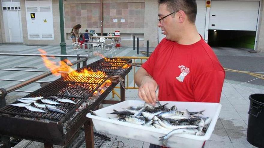 Un vecino prepara la tradicional sardiñada de la noche de San Xoan.