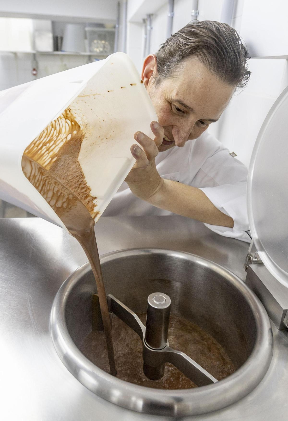 Un artesano durante la elaboración del chocolate en la heladería Món Gelat de la playa de San Juan
