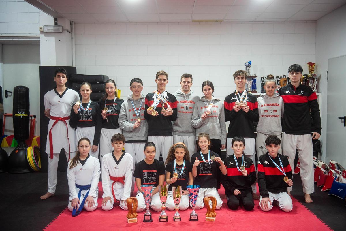 Los alumnos del JFR Taekwondo y Juan Fernández posan con algunos de los trofeos cosechados en estos cinco años.