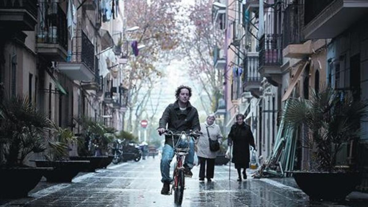Un joven usuario del Bicing recorre una de las calles peatonales de la Barceloneta aprovechando una tregua de la intensa lluvia de ayer.