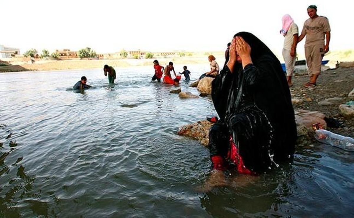Una dona iraquiana es mulla el cos al riu Tigris. L’Administració General de Supervisió Meteorològica Nacional ha alertat que les temperatures arribaran als 50 graus a Bagdad.