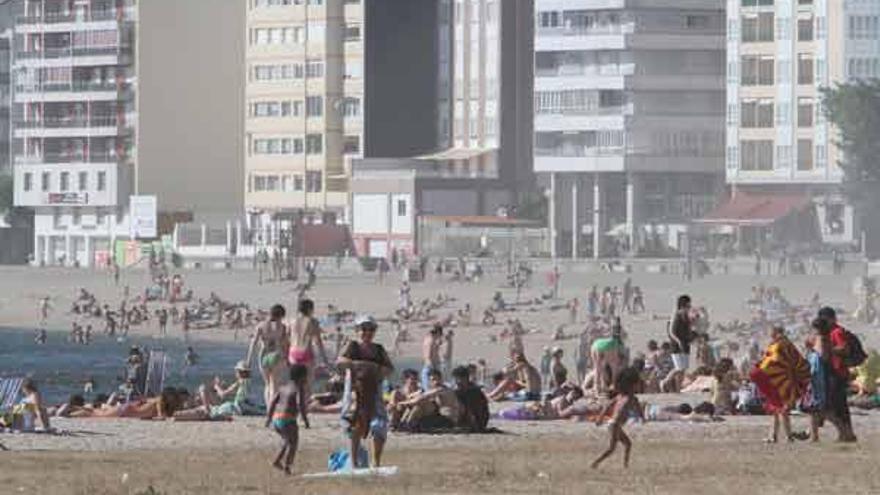 Playa de A Compostela, con pisos al fondo que también se alquilan en verano.  // J.L.Oubiña