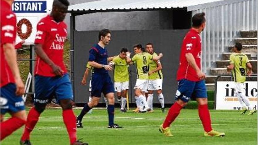 Els jugadors de l&#039;Hospitalet celebren un gol diumenge a Olot, amb diversos locals abatuts en primer pla.