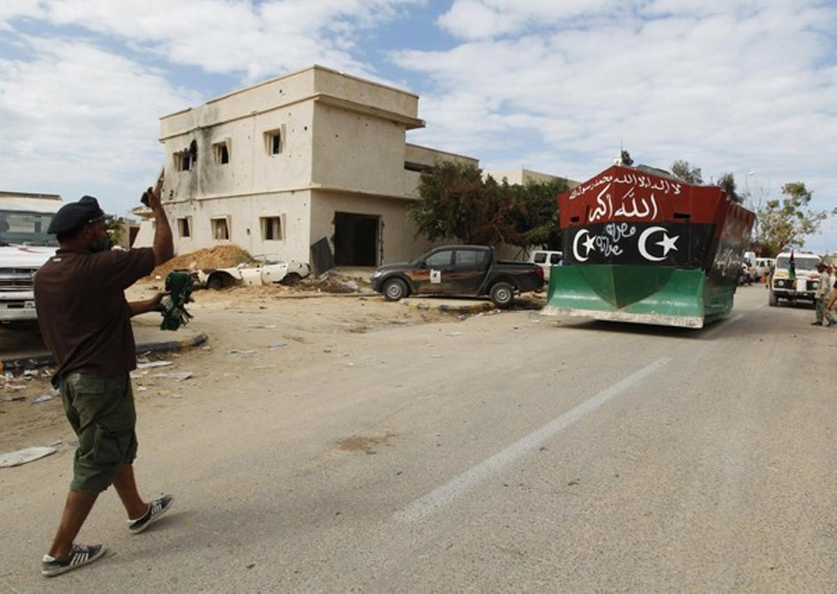 Un rebel guia un vehicle blindat a través dels carrers de Sirte.