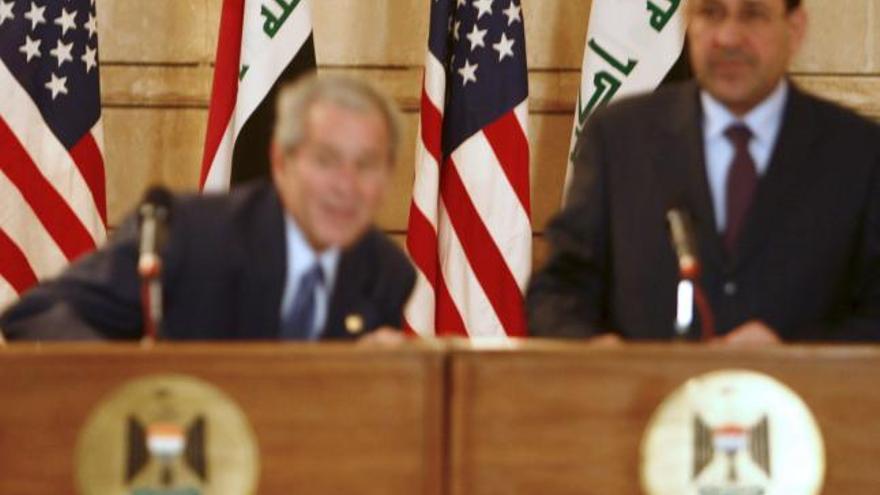 El presidente estadounidense, George W. Bush  se agacha en el momento en el que un periodista iraquí le lanza sus zapatos durante la rueda de prensa que ofreció junto al primer ministro iraquí, Nuri Al Maliki , en Bagdad, Irak.