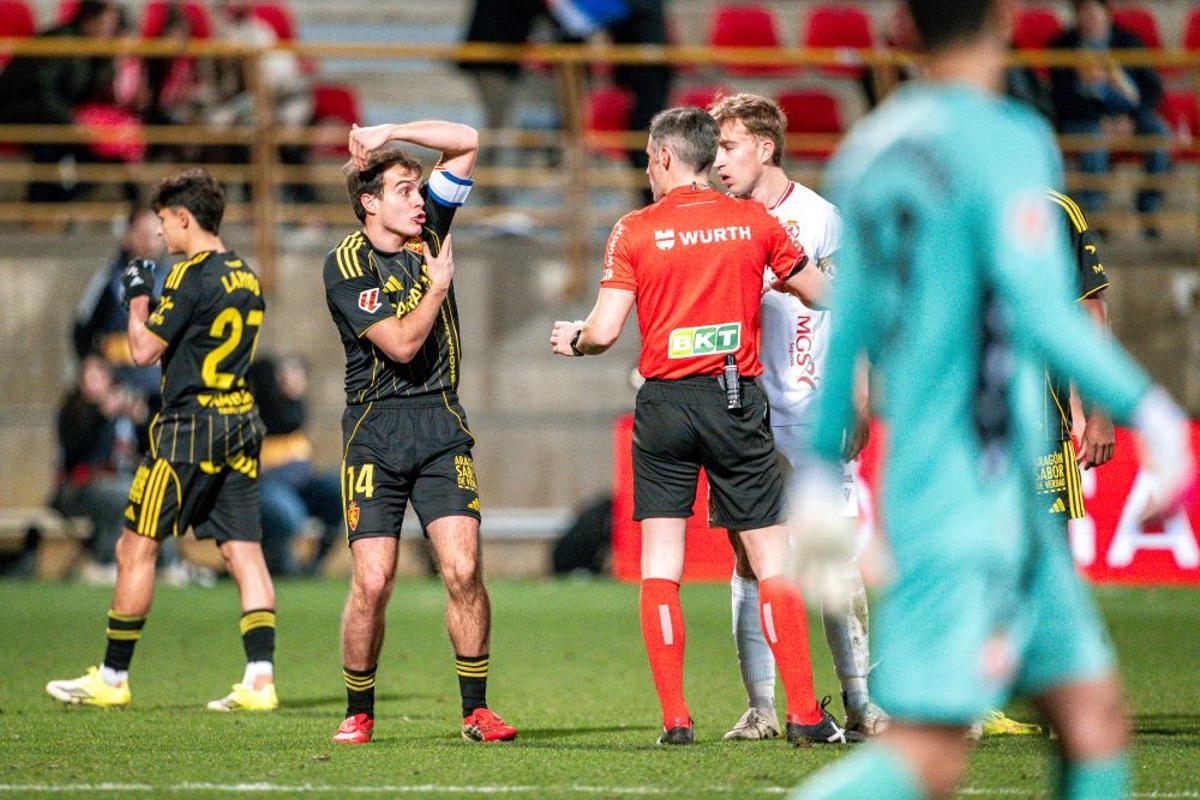 Francho Serrano le señala al colegiado el sitio donde le impacta el balón.