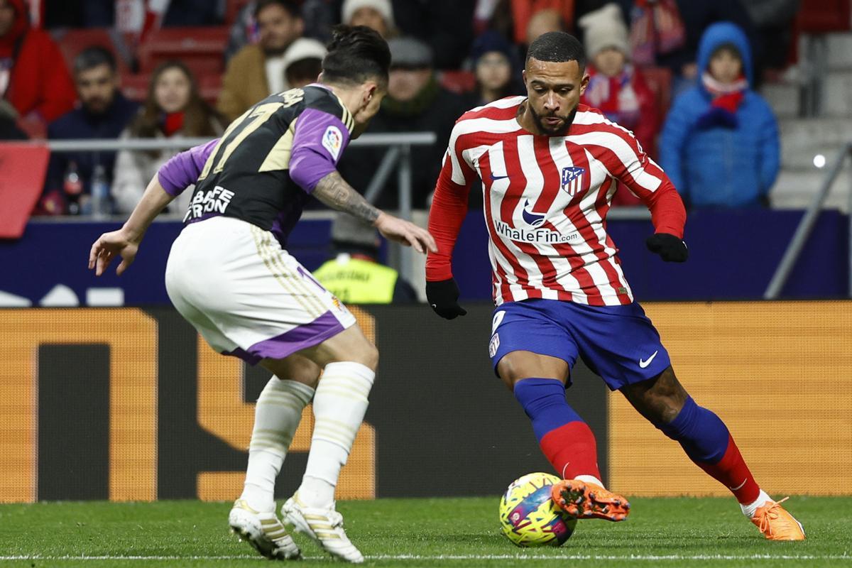 MADRID, 21/01/2023.- El delantero del Atlético de Madrid Memphis Depay (d) juega un balón ante Roque Mesa, del Valladolid, durante el partido de LaLiga que Atlético de Madrid y Real Valladolid disputan este sábado en el estadio Civitas Metropolitano. EFE/Rodrigo Jiménez