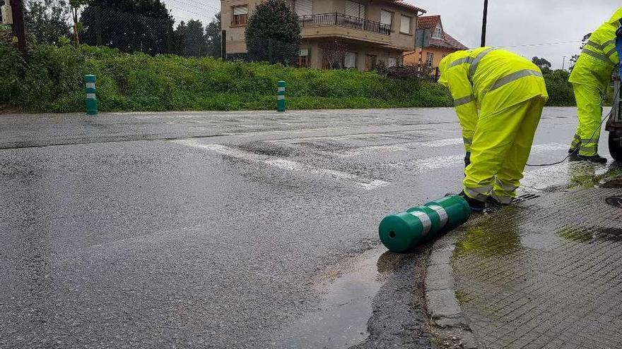 Operarios, ayer, instalando los pivotes en un paso de peatones de Tirán. // G. Núñez