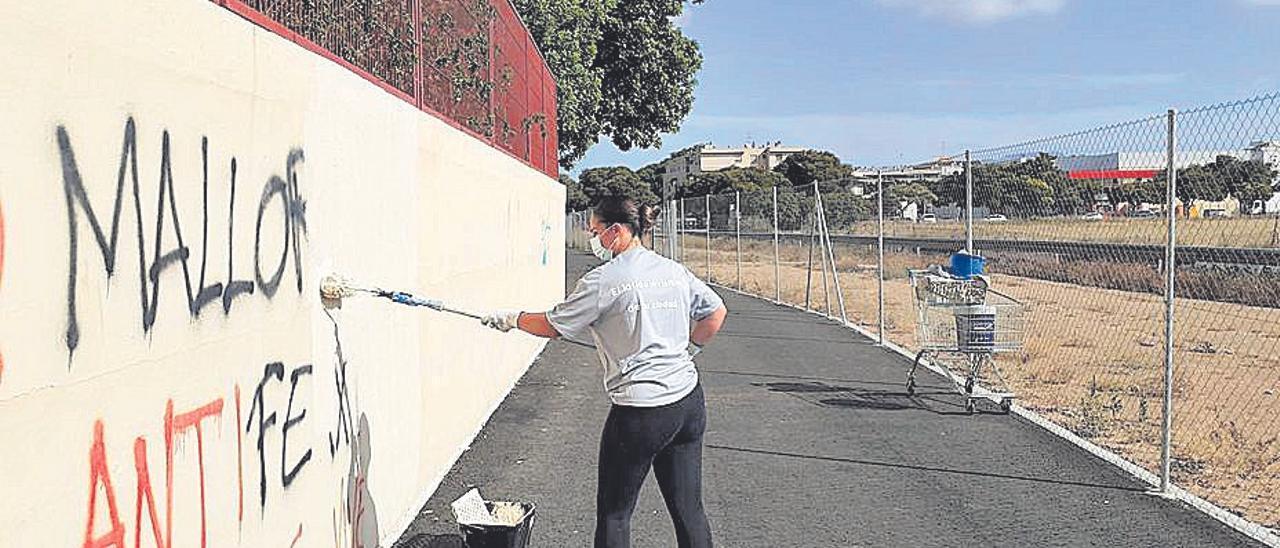 Una auxiliar de mantenimiento limpia una pintada.