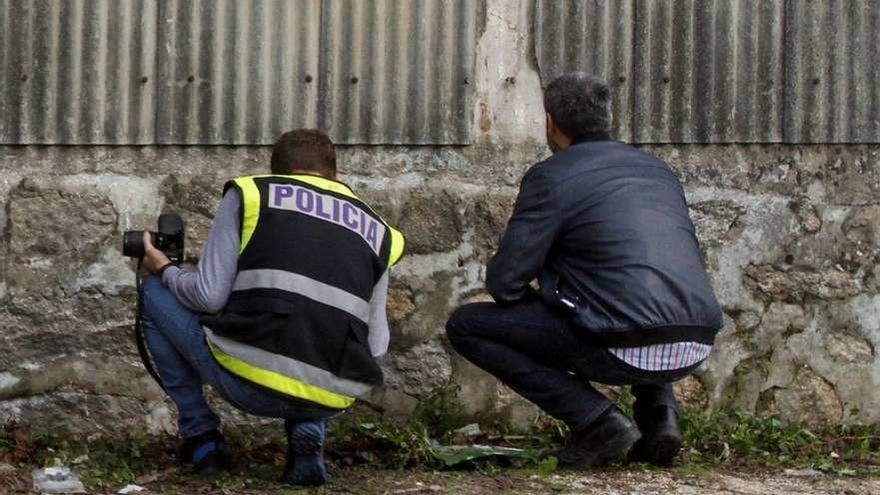 Dos agentes de la Policía examinan el lugar donde se produjo el tiroteo. // Iñaki Abella