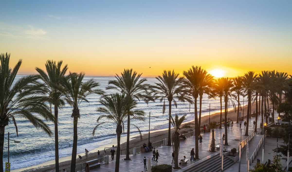 Marbella sunset beach in Playa de la Fontanilla in Malaga province of Spain. Fontanilla is the mostpopular beach with a promenade just downtown Marbella city and beautiful palm trees. Just beside the city marina dock.