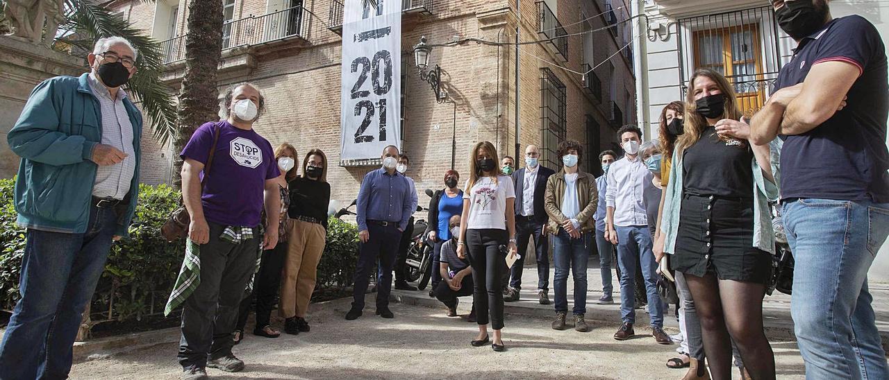 Participantes en el coloquio ante una pancarta que dice «15M, 2011-2021», ayer en la Plaça del Carme de València. | JM LÓPEZ