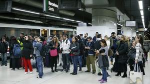 Un grupo de viajeros observa los paneles informativos en la estación de Sants de Barcelona.