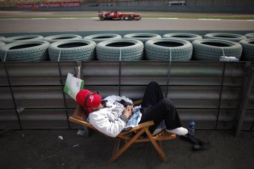 Un encargado de pista duerme durante los entrenamientos de Fernando Alonso en el Gran Premio de Shanghai