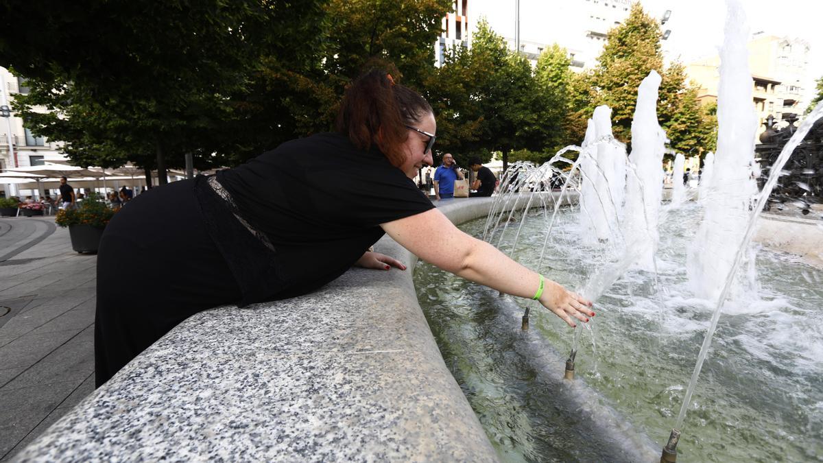 Una mujer se refresca ayer en Zaragoza en una fuente del casco histórico.