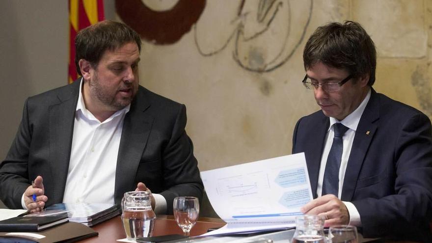 El conseller de Economía, Oriol Junqueras, y Carles Puigdemont, con los Presupuestos catalanes para el próximo año.