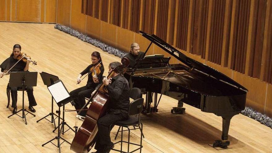 Denis Kozhukhin, al piano, al fondo de la imagen, durante el concierto de ayer en el Auditorio.