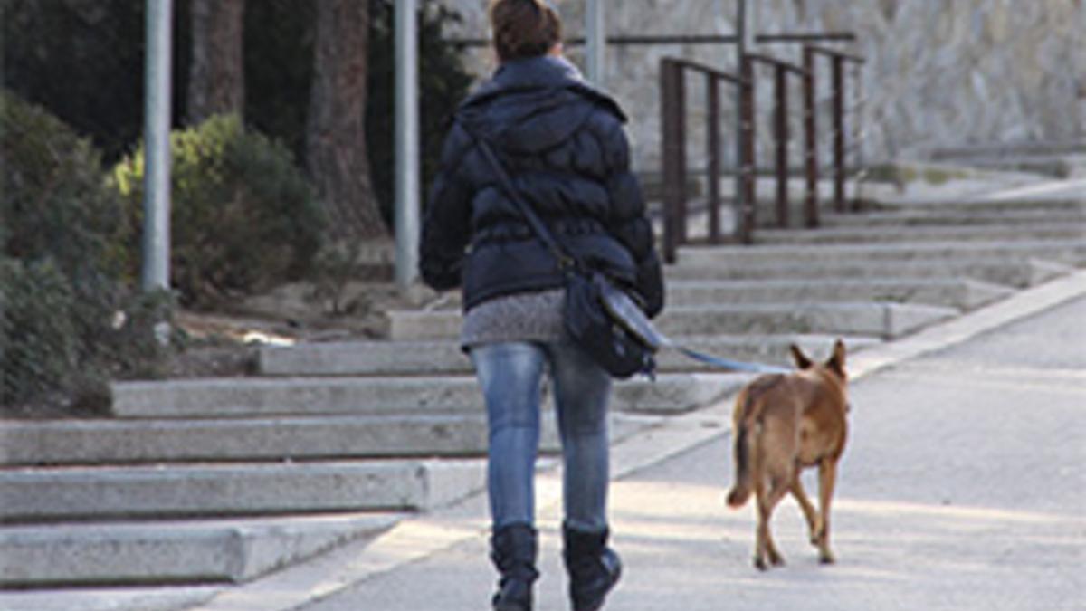 Una chica con su perro por las calles de Sant Boi.