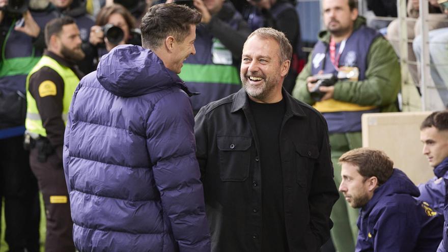 Lewandowski y Flick conversan antes de la entrada del delantero polaco al campo.