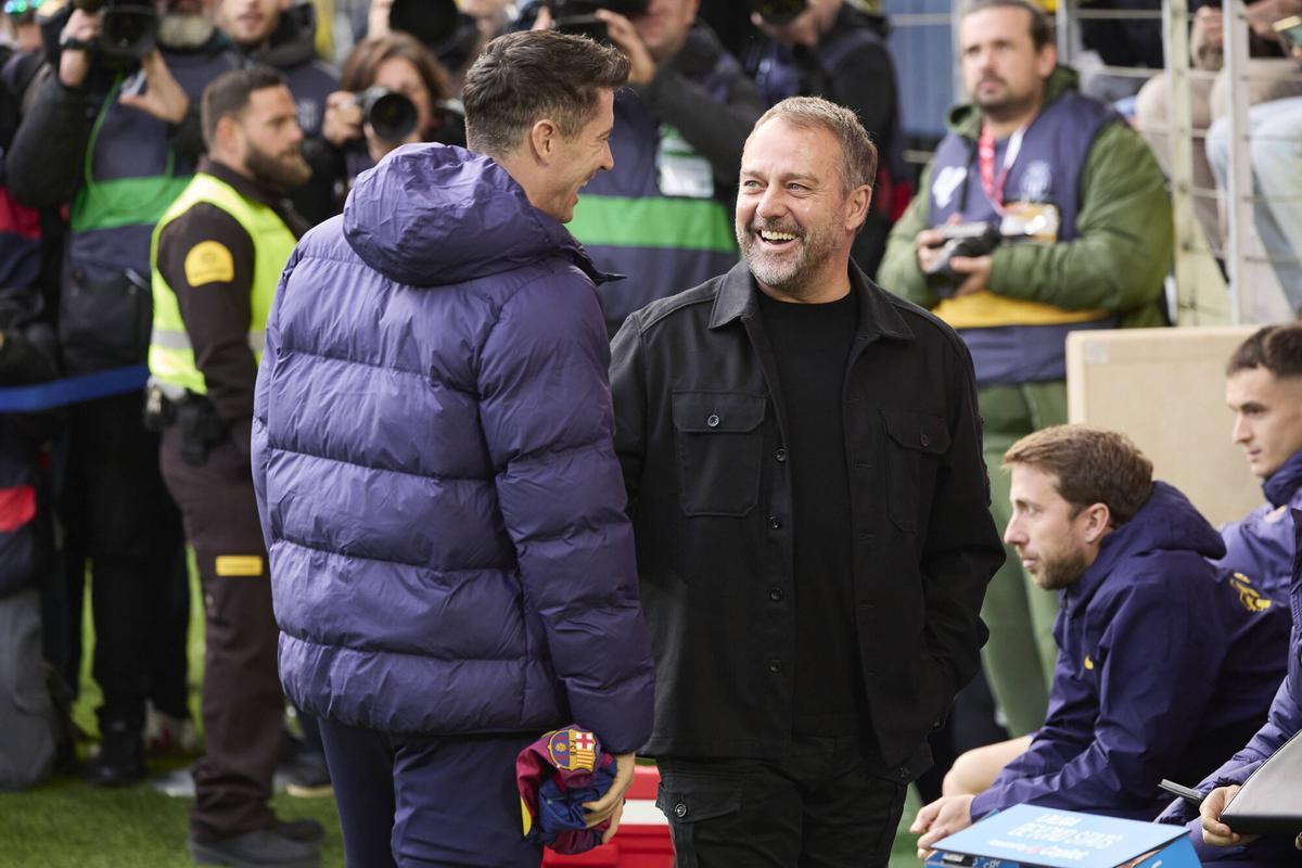 Lewandowski y Flick conversan antes de la entrada del delantero polaco al campo.