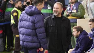 Lewandowski y Flick conversan antes de la entrada del delantero polaco al campo.
