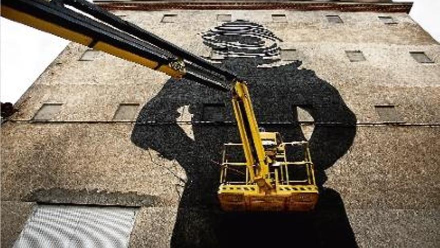 Un dels artistes en plena feina, en una paret del barri de Sant Narcís.