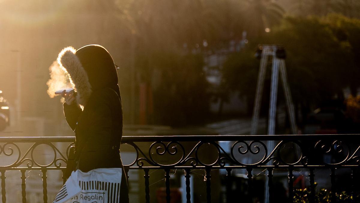 Una persona cruza el Puente de Triana durante la ola de frío en Sevilla