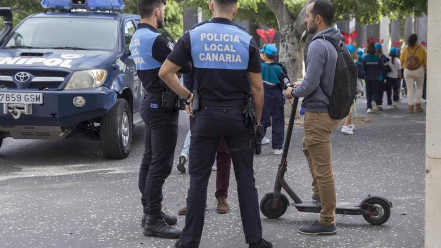 Dos agentes informan a un ciudadano sobre el uso del patinete eléctrico en Santa Cruz.