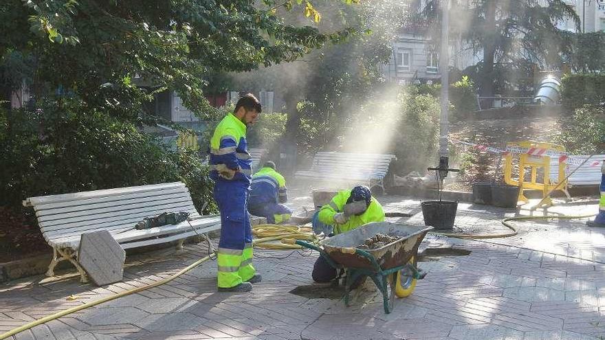 Varios operarios trabajan en la reparación de un parque.