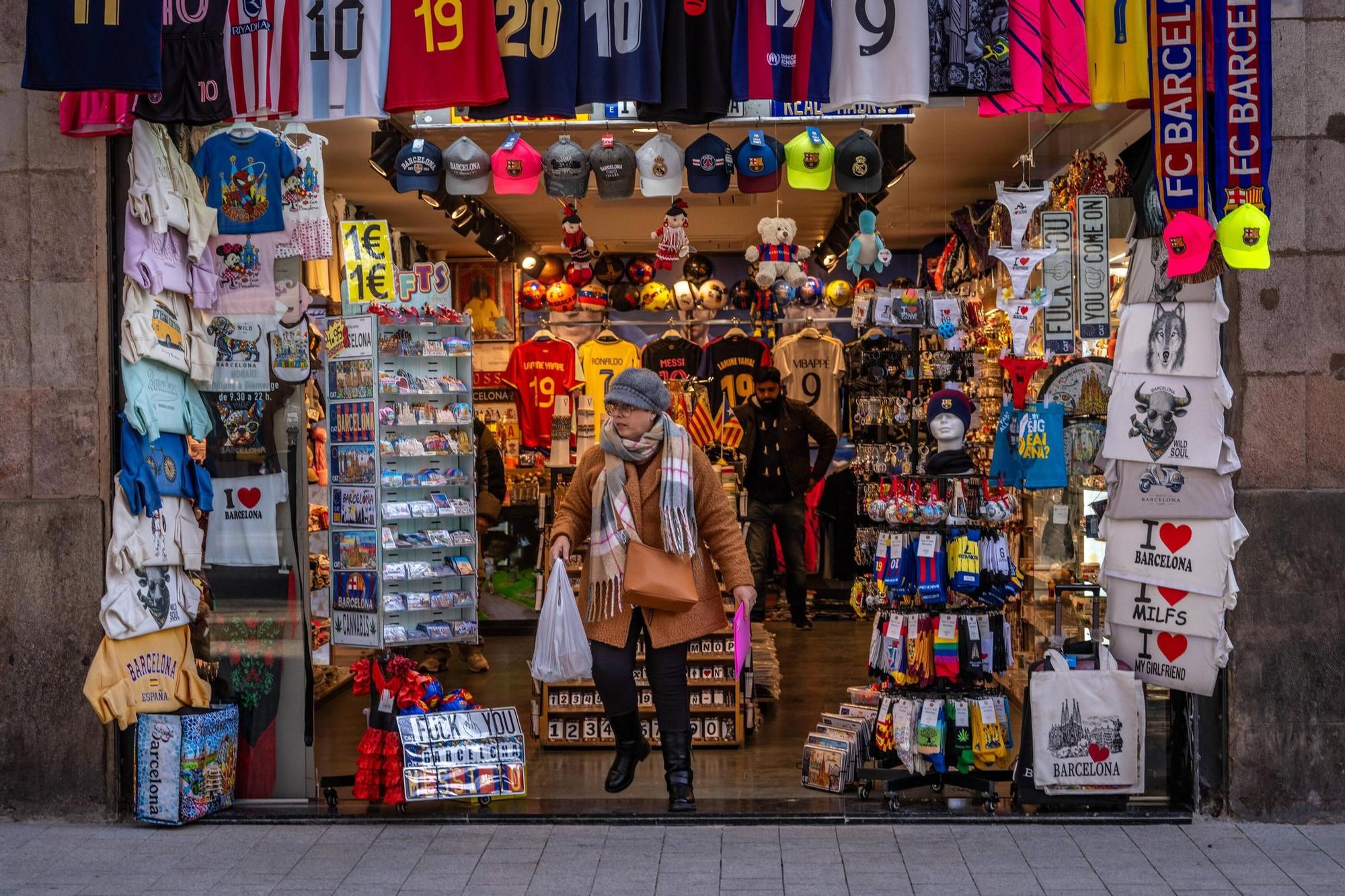 Una clienta saliendo de una tienda de 'souvenirs', en Barcelona.