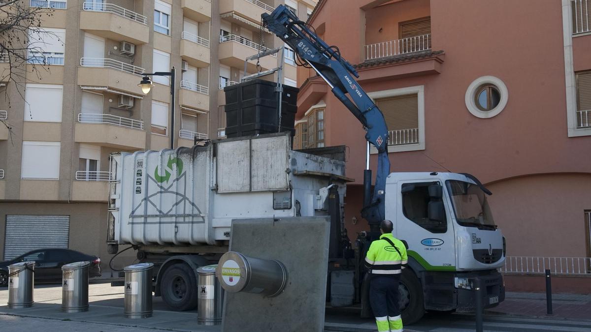 Un camió retira retira els residus de contenidors en un carrer d'Ontinyent.
