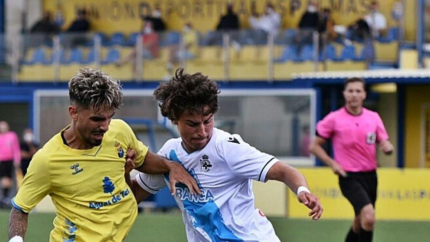 Guille Bueno forcejea con un jugador de Las Palmas. |  // RCD
