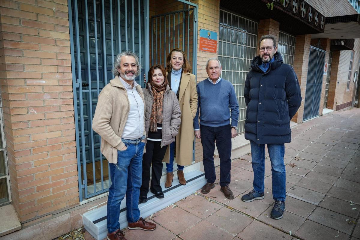 Voluntarios del Centro de Escucha San Camilo posan junto al director en la puerta del local.